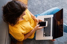 Girl looking at phone and computer