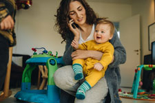 Mother smiling at her baby using phone
