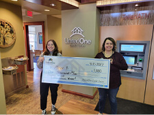 UnitedOne Branch Manager Kim (right) presents a "big" winning check to Allison, a UnitedOne member.