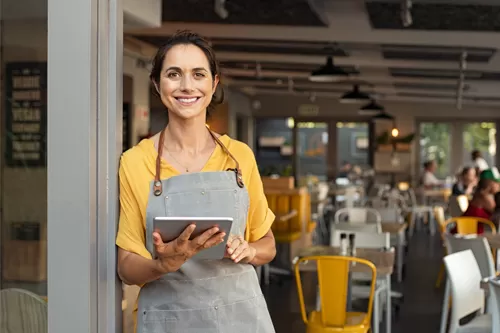 Restaurant owner with ipad in front of restaurant