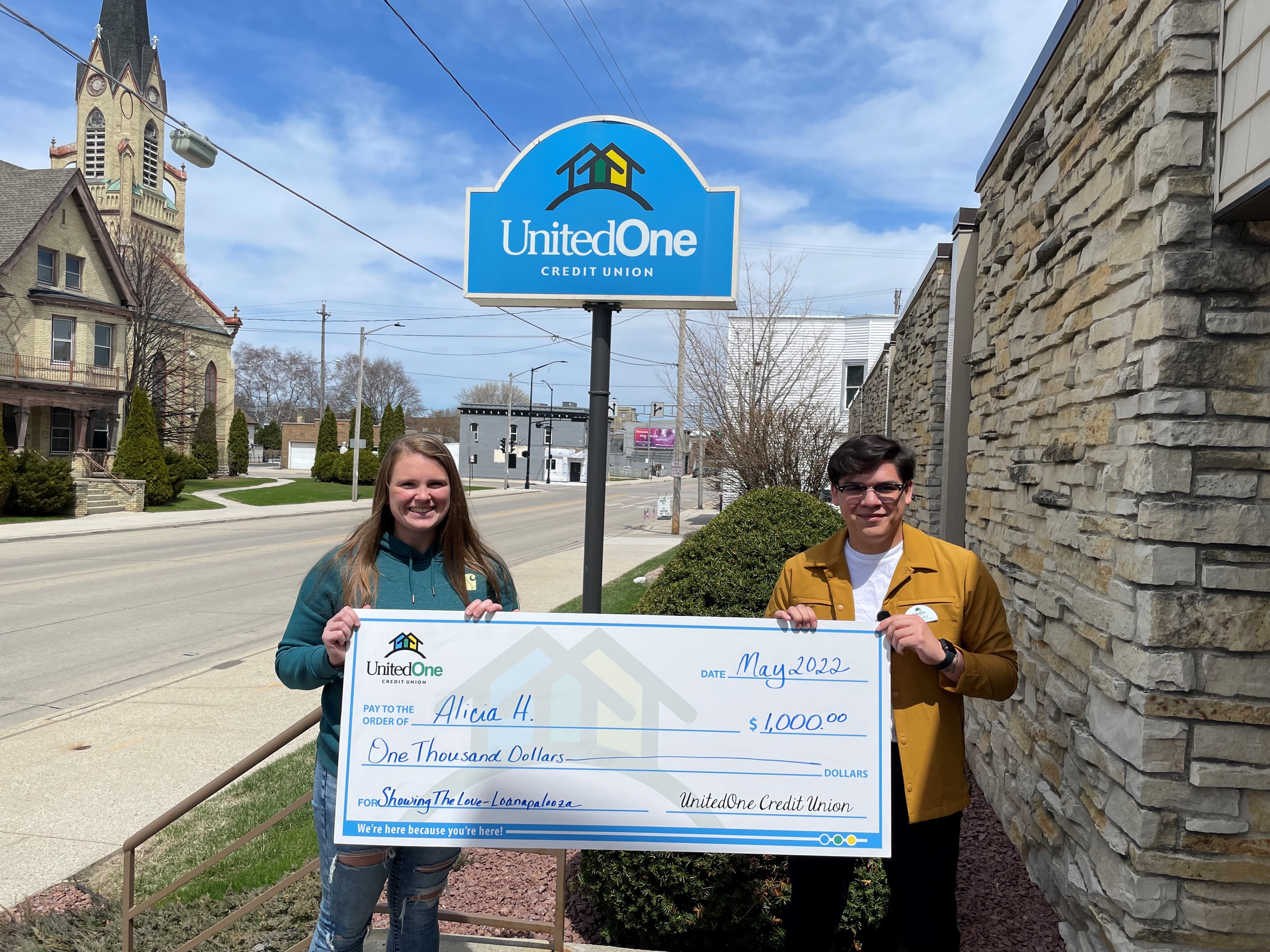 UnitedOne CU Showing the Love Loanapalooza winner holding $1,000 check
