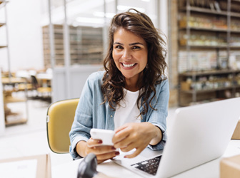Woman smiling while holding a cell phone
