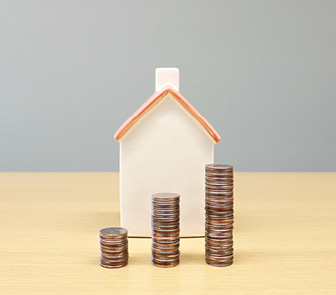Model home with coins stacked in front