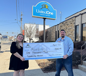 Chief Marketing Officer Mike Farley presents a scholarship donation check to Meredith Putman of Manitowoc