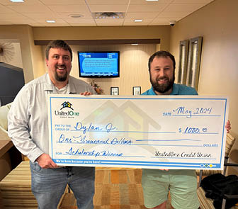 Chief Marketing Officer Mike Farley presents a scholarship donation check to Dylan Johnston of Manitowoc