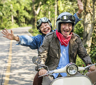 Image of an older couple driving a scooter